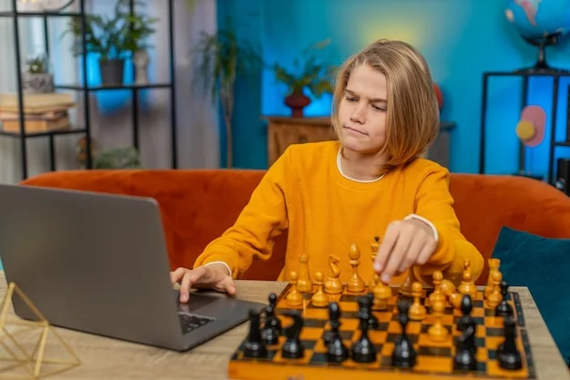Blonde boy in yellow shirt intensely playing chess on a wooden board, with a laptop open beside him, in a home setting.